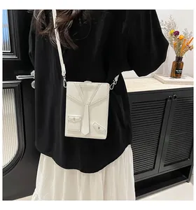 Detailed shot of white leather crossbody bag featuring unique tuxedo design and lychee texture