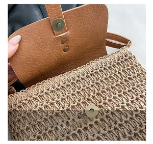 Detail of woven straw saddle bag featuring brown leather flap and antique bronze magnetic clasp