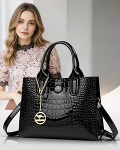 Detailed view of black patent leather handbag with crocodile pattern and golden kangaroo charm