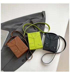 Detail of creative suit-style crossbody bags in brown, lime green, and black leather
