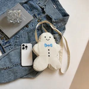 Detail van de schattige peperkoekman crossbodytas met borduurwerk en lange riem