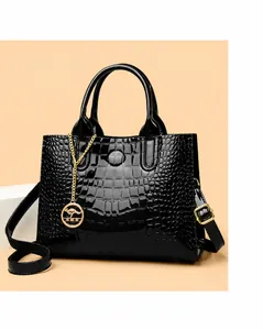 Close-up of black crocodile pattern patent leather handbag with golden kangaroo charm