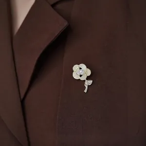 Elegant floral shell brooch with pearl on a dark blazer lapel for a sophisticated look