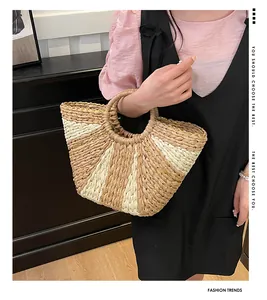 Détail du sac à main en paille tissée avec rayures verticales et bordure en chaîne dorée