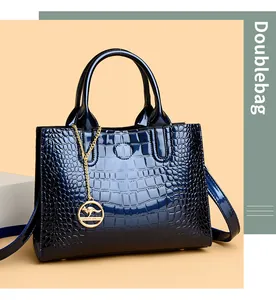 Close-up of deep blue crocodile pattern handbag with glossy finish and gold pendant
