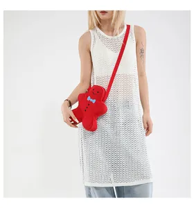 Gingerbread man crossbody bag with blue bowtie and red plush fabric detail on model