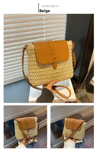 Detail of beige straw saddle bag featuring brown leather flap and metal buckles