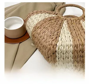 Détails du sac à main en paille tressée avec larges rayures bicolores et anses rondes
