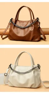 Detail of pebbled leather tote bag in brown and cream with metallic chain decor