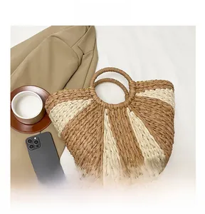 Vue détaillée du sac cabas en paille tressée à rayures marron et crème pour l'été