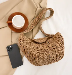 Détail de la texture crochetée sur le sac bandoulière en paille marron en style de vie