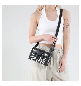 Detail of a zebra print box bag with black corner protectors and a metallic clasp
