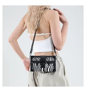 Detail view of zebra print box clutch with black metal trim and leather strap