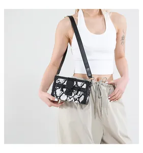 Detail of a rectangular box bag featuring black and white snakeskin pattern and metal clasp