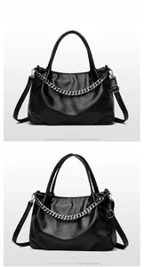 Detail view of black faux leather tote bag with silver chain and adjustable strap