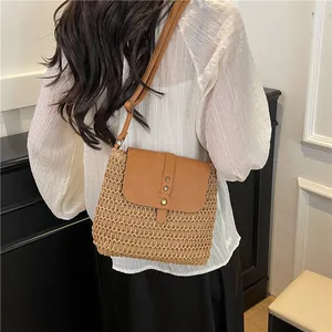 Handwoven straw and brown leather crossbody bag for women on a model for summer beach