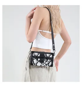 Detail of snake skin pattern box bag with black metal corners and vintage clasp