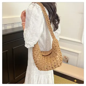 Gros plan du sac porté épaule en paille kaki avec motif crocheté et bandoulière large