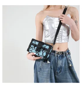 Close-up of snake pattern box bag with black metal trim and push-lock closure