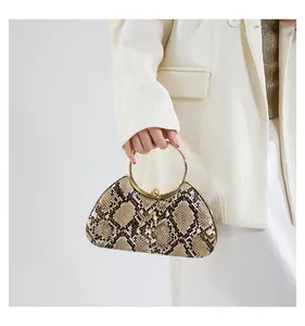 Macro detail of faux snakeskin texture and gold ring handle on stylish evening clutch