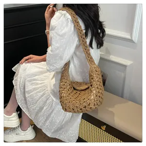 Gros plan du sac hobo en paille tressée kaki avec texture au crochet et bandoulière large