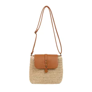Handwoven straw crossbody bag with brown leather flap and adjustable shoulder strap