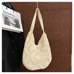 Détail d'un sac bandoulière crocheté à la main en crème avec motifs floraux