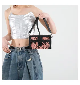 Pink and black snake pattern box bag with metal rivets shown on a fashion model