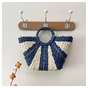 Détail du sac cabas tissé avec rayures bleues et beige et fils dorés discrets