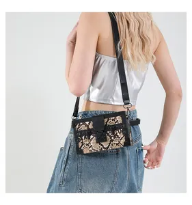 Detail of snake print box bag featuring black leather trim and dark metal buckle hardware