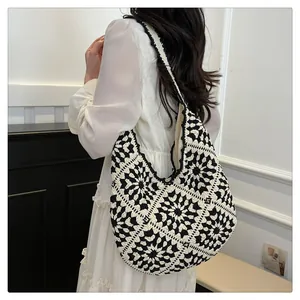 Detail of bohemian black and white hand-crocheted shoulder bag with geometric floral patterns