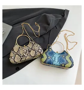 Detail of snakeskin textured clutch bags in taupe and teal with gold circular handles