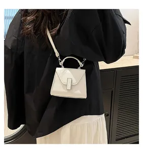 Detail der weißen Mini-Tasche aus PU-Leder mit Lychee-Muster und elegantem Metallschloss