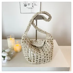 Détail du sac à bandoulière en crochet crème montrant la texture ajourée et la bandoulière