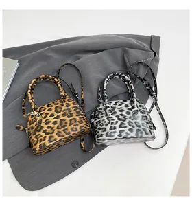 Nahaufnahme eleganter Schlangenhaut-Muscheltaschen in Braun und Grau mit Silberbeschlägen