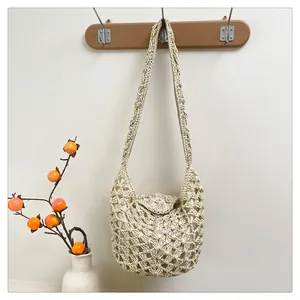 Détail de la texture crochetée beige ajourée et de la doublure d'un sac hobo tissé
