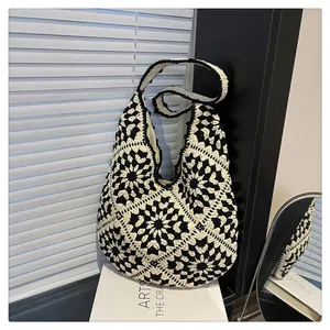 Close-up of black and white crochet hobo bag with classic grandmother square patterns