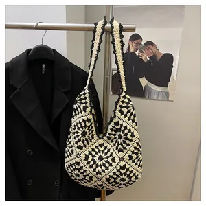 Detail of black and white granny square crochet tote bag with flower pattern texture
