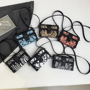 Fashionable box-shaped crossbody bags in snakeskin and zebra patterns with metal studs