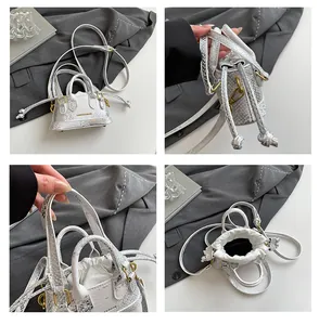 Detailansicht der silbernen Schlangenhaut-Beuteltasche mit Kordelzug und Textur-Finish