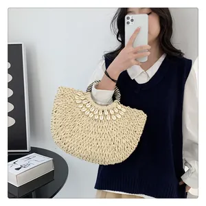 Detailansicht der handgefertigten Strohtasche mit Muschelbesatz und Streifengriff