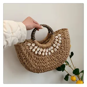 Detail der Strohtasche mit Muschelbesatz, Rundgriff und Naturfaser-Struktur für Sommer