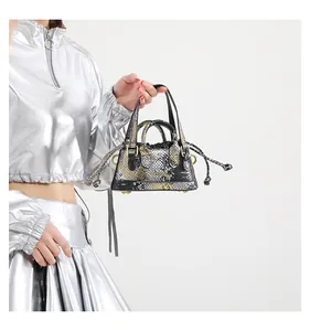 Detailansicht der Mini-Eimertasche mit Schlangenmuster, Metallic-Finish und goldenen Details