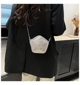 Detail of silver star-shaped mini crossbody bag with fine chain and metallic texture