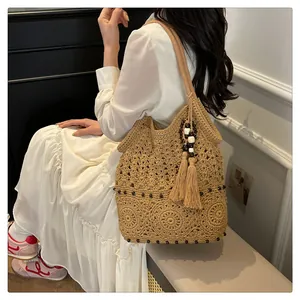 Close-up of bohemian hollow-out straw bag with tassels and decorative wooden beads