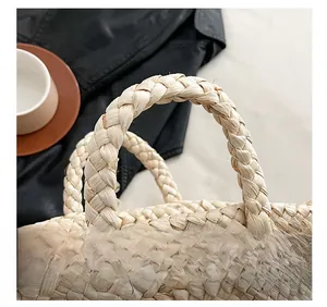 Detail of the woven thick handle design on a natural straw basket bag for women
