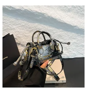 Detailansicht der Beuteltasche mit Metallic-Schlangenprint-Pailletten und Kordelzugverschluss