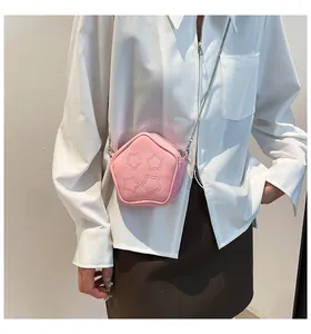 Close-up of pink pentagon crossbody bag with star stitching and stylish metal chain