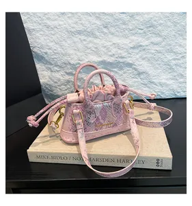 Nahaufnahme der rosa Schlangenhaut-Handtasche mit Kordelzug und goldenen Beschlägen