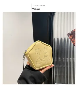 Close-up of a star-shaped yellow crossbody bag with silver chain and quilted texture